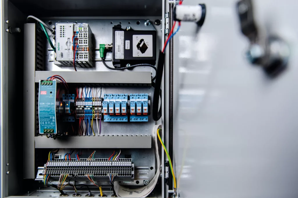 Professioneel geïnstalleerde elektrische schakelkast met relais, bekabeling en industriële componenten