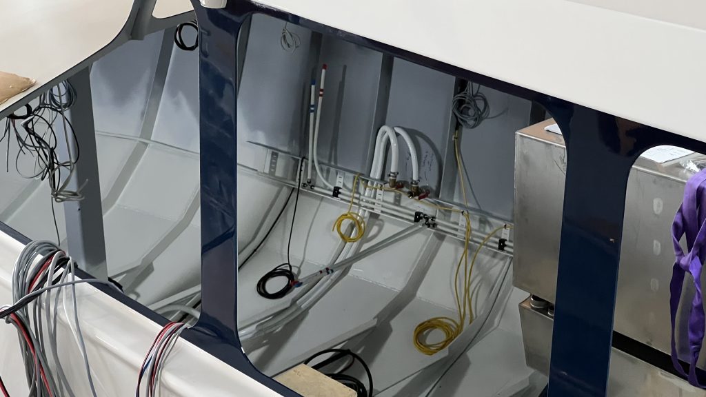 Onderhoud en reparatie van motorruimte in boot met technische installaties en leidingen