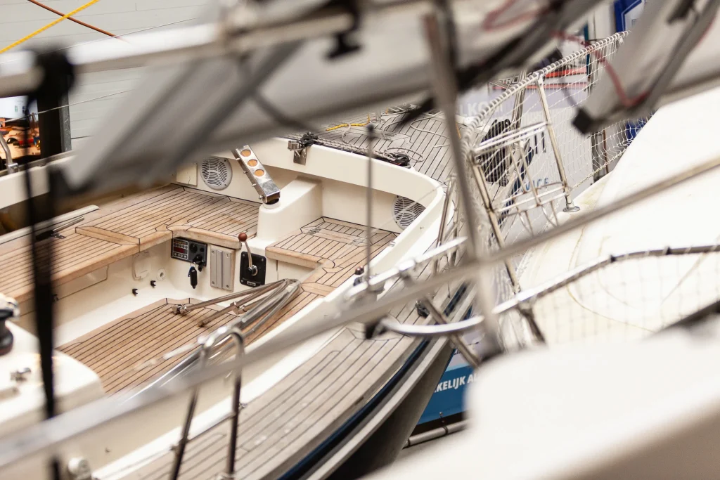 Professioneel onderhoud en reiniging van luxe zeilboot met wit dek en mast in jachthaven